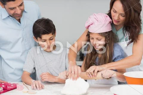 Family of four preparing cookies in the kitchen Stock Photos
