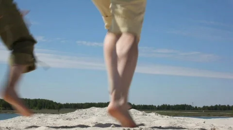 Family of four runs on sand, view from back Stock Footage