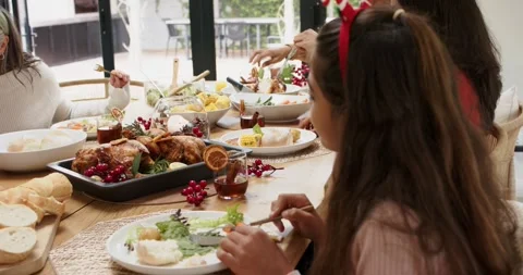 Family gathering around dining table, grandmother smiling as girl starting Stock Footage 338325623