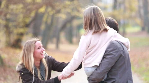 Family having fun in park, father carries daughter in his arms Stock Footage 59554274