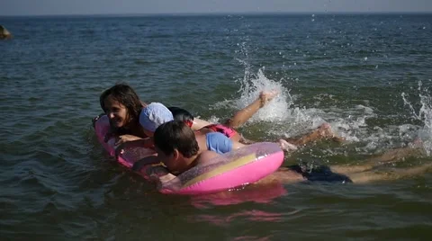 Family having fun playing on inflatable mattress 動画素材 66428582