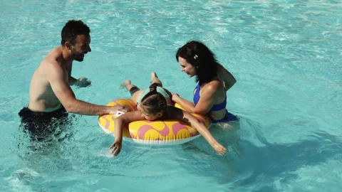 Family having fun together in clear blue swimming pool Stock Footage 337251069