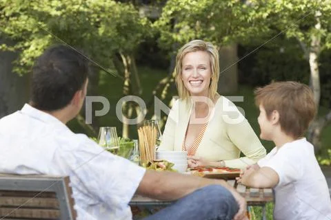Family Having Meal At Picnic Table Stock Photos