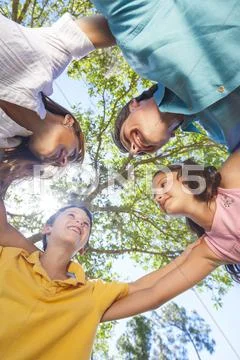Family huddle together outside in sunshine Stock Photos