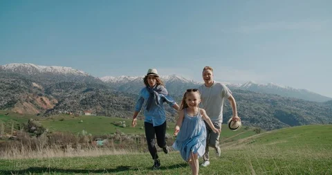 Family idyll concept, a young family with a little daughter run happily, have Stock Footage