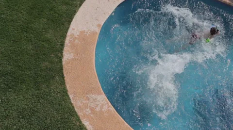 Family jumping into pool, overhead view Stock Footage