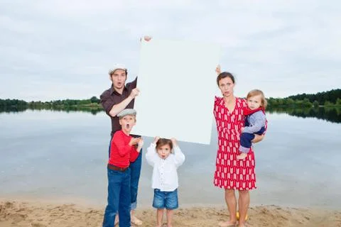 Family by lake, holding a blank sign Stock Photos