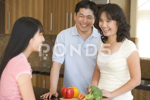 Family laughing while preparing meal,mealtime Stock Photos
