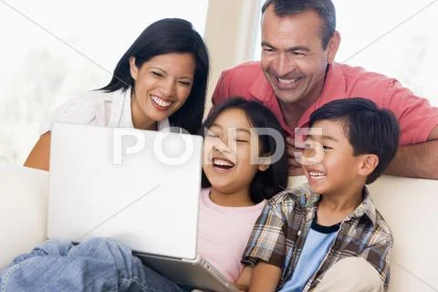 Family in living room with laptop smiling Stock-Fotos
