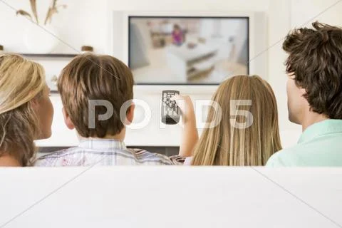 Family in living room with remote control and flat screen television Stock Photos