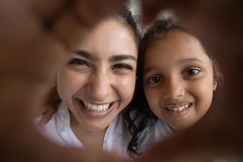 Family looking at camera through joined fingers showing heart symbol Stock Photos