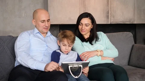 Family is looking at a tablet computer Video stock 89471610