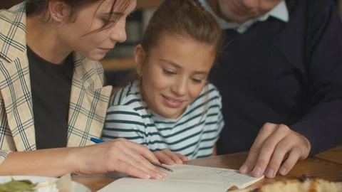 Family lunch, mother write in notebook and daughter laughs Stock Footage 120796953