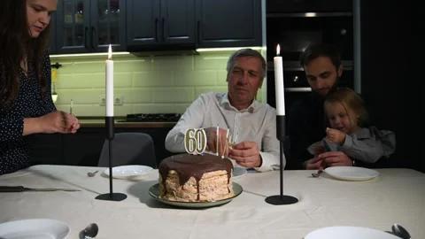 Family members remove extinguished candles from a birthday cake 库存影片 340063406