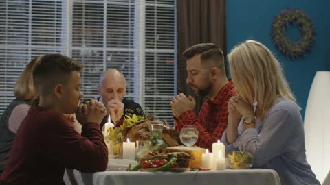 Family offering prayers before Thanksgiving meal Stock Footage
