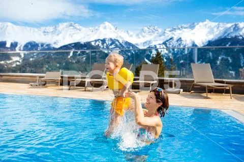 Family in outdoor swimming pool of alpine spa resort Stock Photos