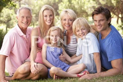 A family, with parents, children and grandparents, relaxing in a park Stock Photos