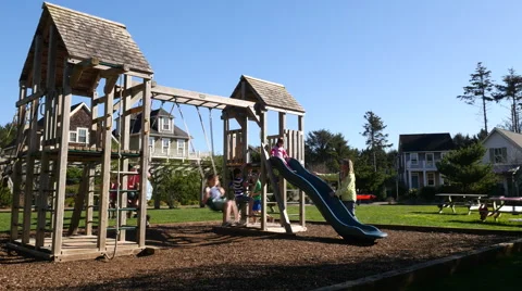 Family playing at park playground Stock Footage