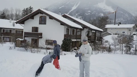 Family playing in snow while flakes fall in Bavaria Stock Footage 121754259
