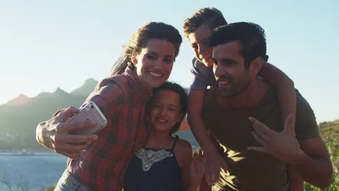 Family Posing For Holiday Selfie On Cliffs By Sea Stock Footage