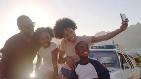 Family Posing For Selfie Next To Car Packed For Road Trip Stock Footage