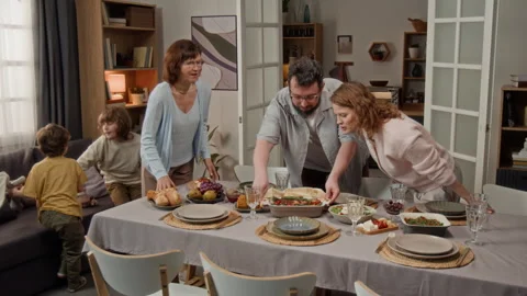 Family Preparing Dinner Table for Festive Celebration at Home Stock Footage 340331990