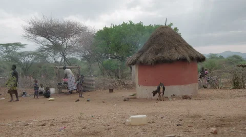 Family preparing meal outside dirt hut in small village.  動画素材 59796087