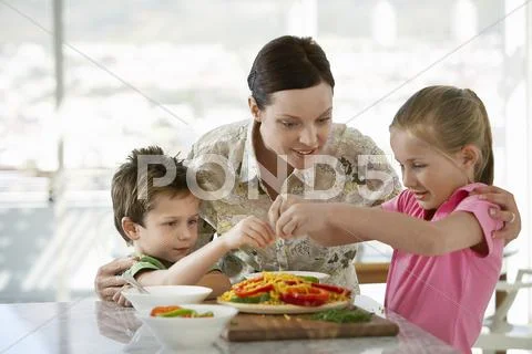 Family Preparing Meal Together In Kitchen Stock Photos