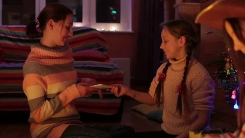 A family presents their presents while sitting under a christmas tree. Stock Footage 76256015