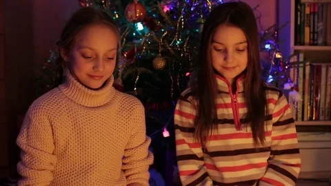 A family presents their presents while sitting under a christmas tree. Stock Footage 76256056
