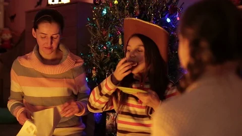 A family presents their presents while sitting under a christmas tree. 스톡 동영상 76256159