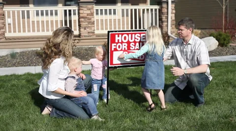 Family puts up SOLD sign in front of home Stock Footage