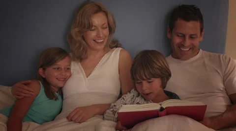 Family reading in bed together. Stock Footage