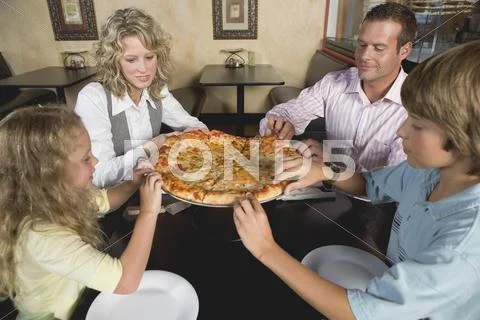 Family in restaurant sharing pizza Stock Photos