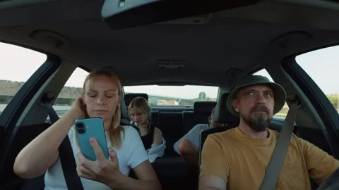 Family road trip unfolding inside comfortable vehicle, woman browsing smart.. Stock Footage 315519200