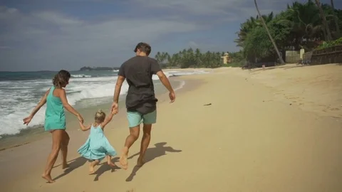 Family running on the sandy beach together at sunny day rapid slow motion Stock Footage 84985553