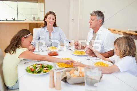 Family saying grace Stock Photos