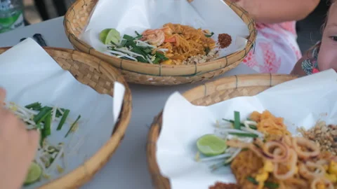 Family sharing multiple pad thai dishes at table Vidéo 338273447
