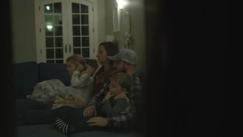 Family Sit Together On Couch While Creepy Child Watches From Outside 스톡 동영상 208748480