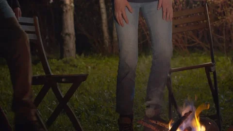 Family sits down by the fire and warms hands Stock Footage 130863395