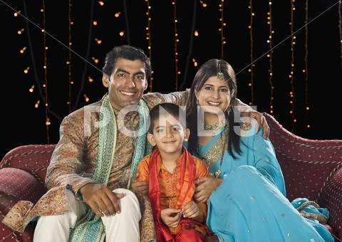 Family sitting on couch and celebrating Diwali festival Stock Photos