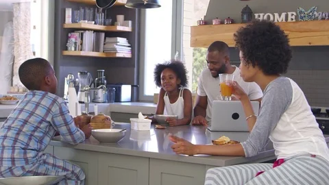 Family Sitting In Kitchen Enjoying Morning Breakfast Together Stock Footage