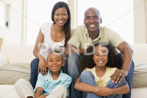 Family sitting in living room smiling Stock-Fotos