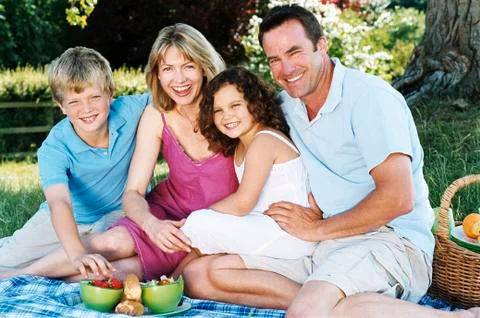 Family sitting outdoors with picnic smiling Stock Photos