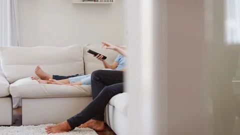 Family Sitting On Sofa At Home Watching TV Together Stock Footage