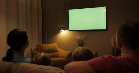 Family Sitting Together Sofa In Their Living Room Night Watching TV Green Scr Stock Footage