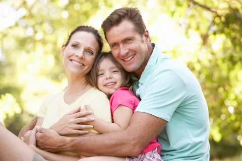 Family Sitting On Tree In Park Stock Photos