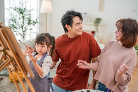 Family spends time together while painting at home in the afternoon sunligh.. Stock Photos