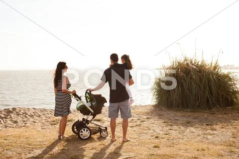 Family Standing On Beach Looking At Sea
