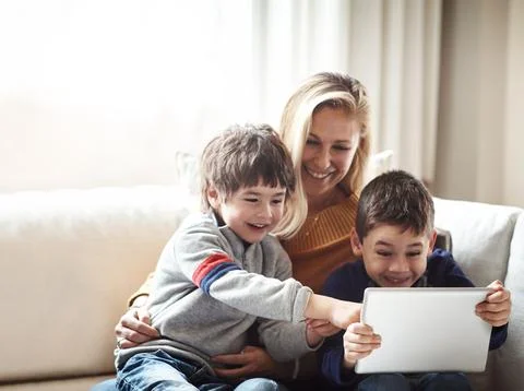 Family, tablet and mother with children on sofa bonding, quality time and relax Stock Photos
